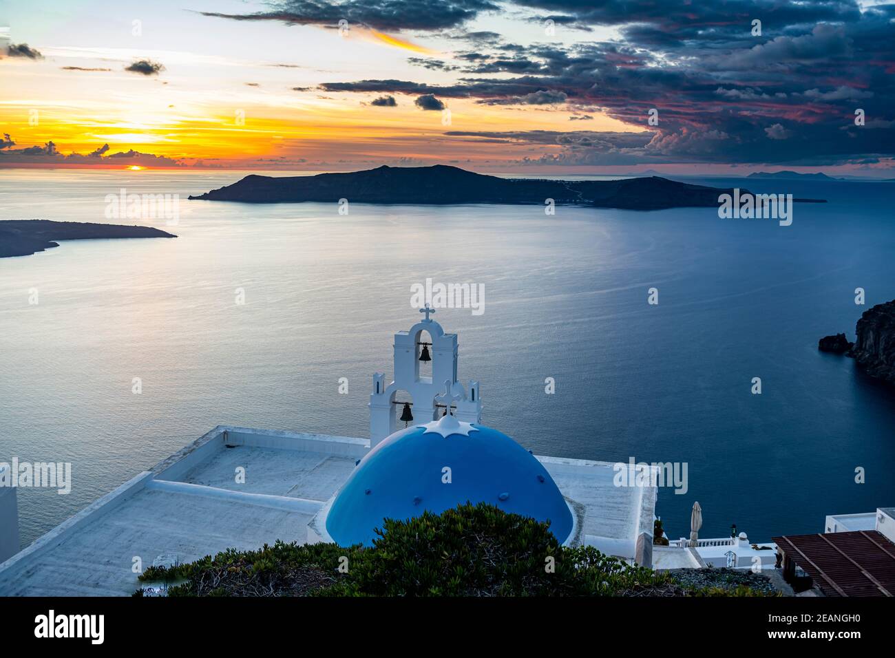 Sunset over the volcanic islands of Santorini and Anastasi Orthodox Church at sunset, Fira, Santorini, Cyclades, Greek Islands, Greece, Europe Stock Photo