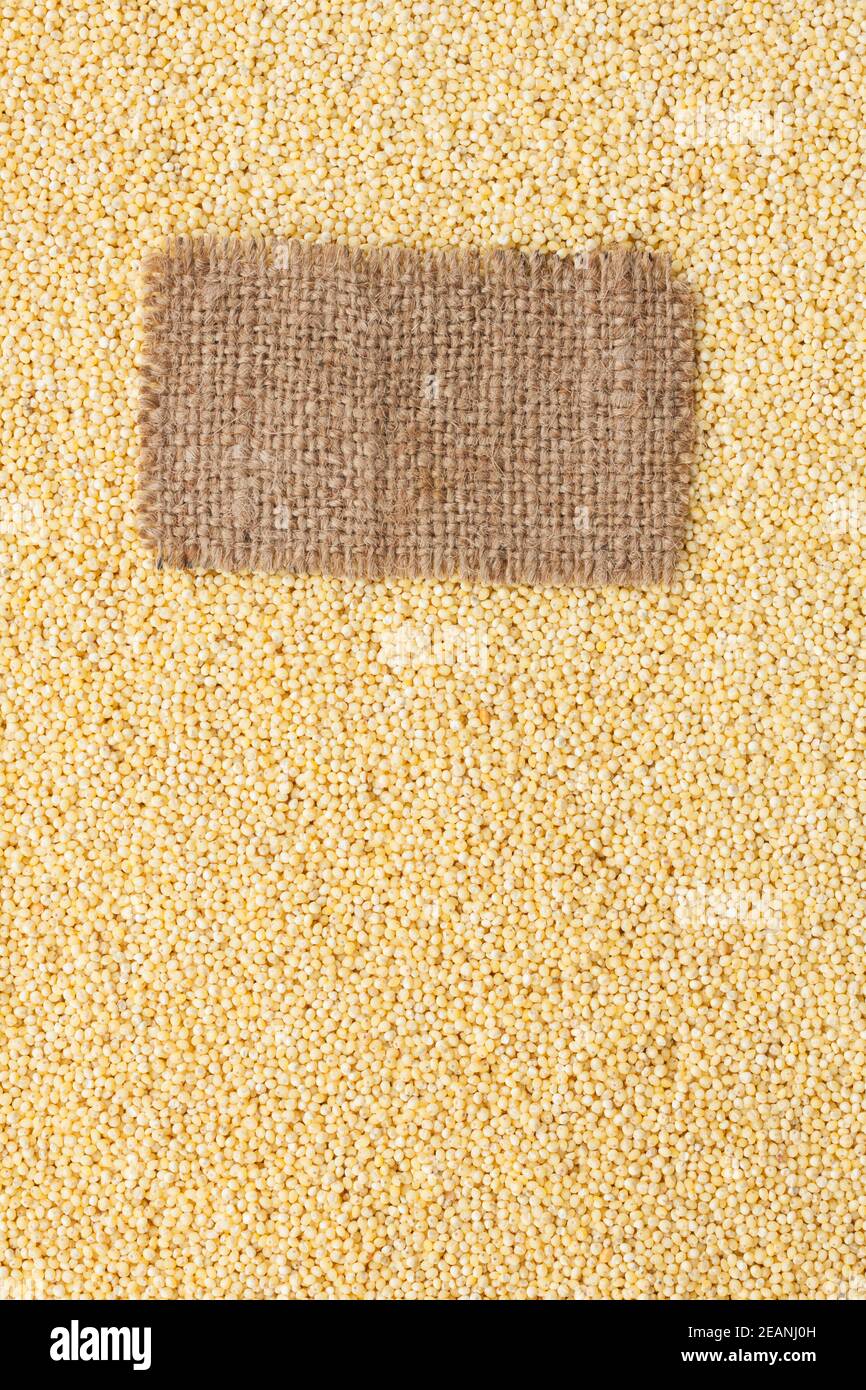 Tag made of burlap lies against the backdrop of millet Stock Photo