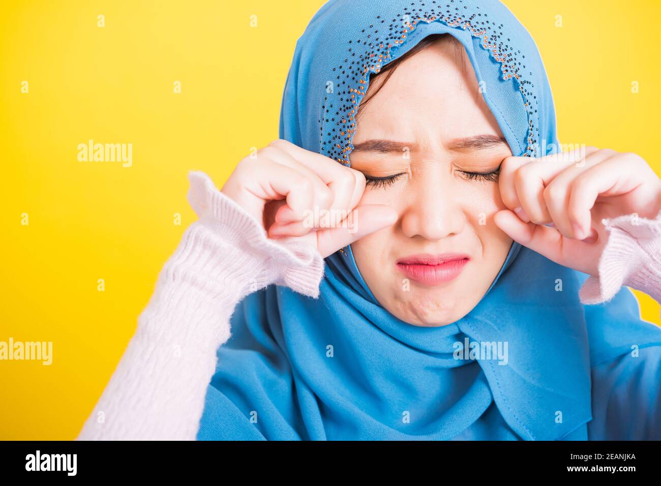 Woman wear veil hijab she sad crying using hand wiping tears in her eyes Stock Photo