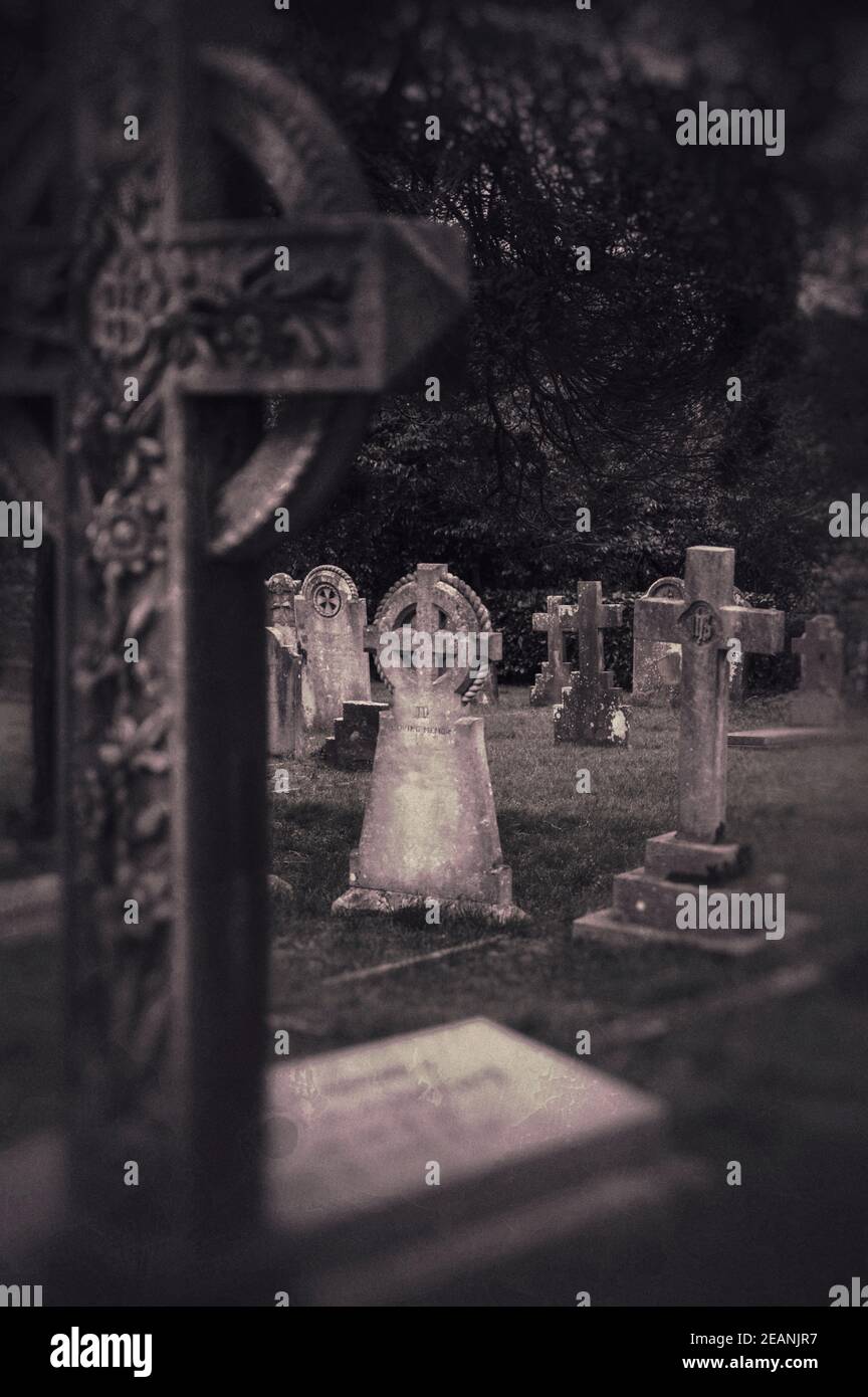 Spooky grunge effect image of graveyard with graves and gravestones. Stock Photo