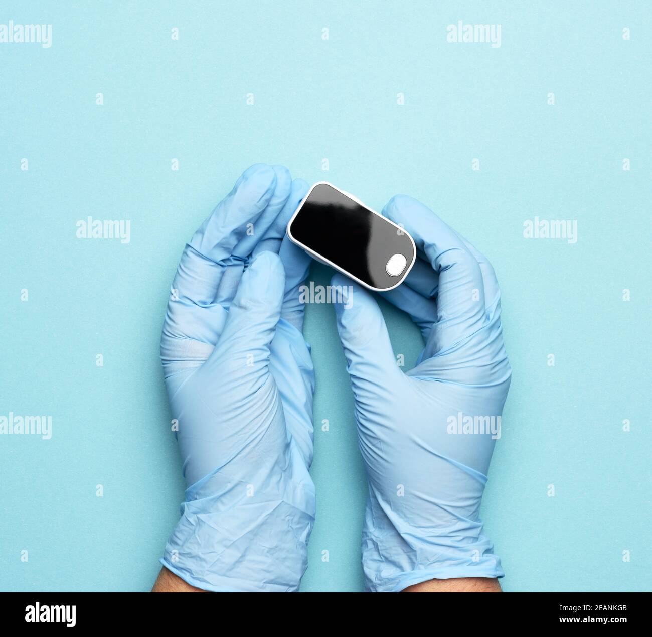 electronic pulse oximeter in the hands of a doctor, wearing blue latex gloves Stock Photo