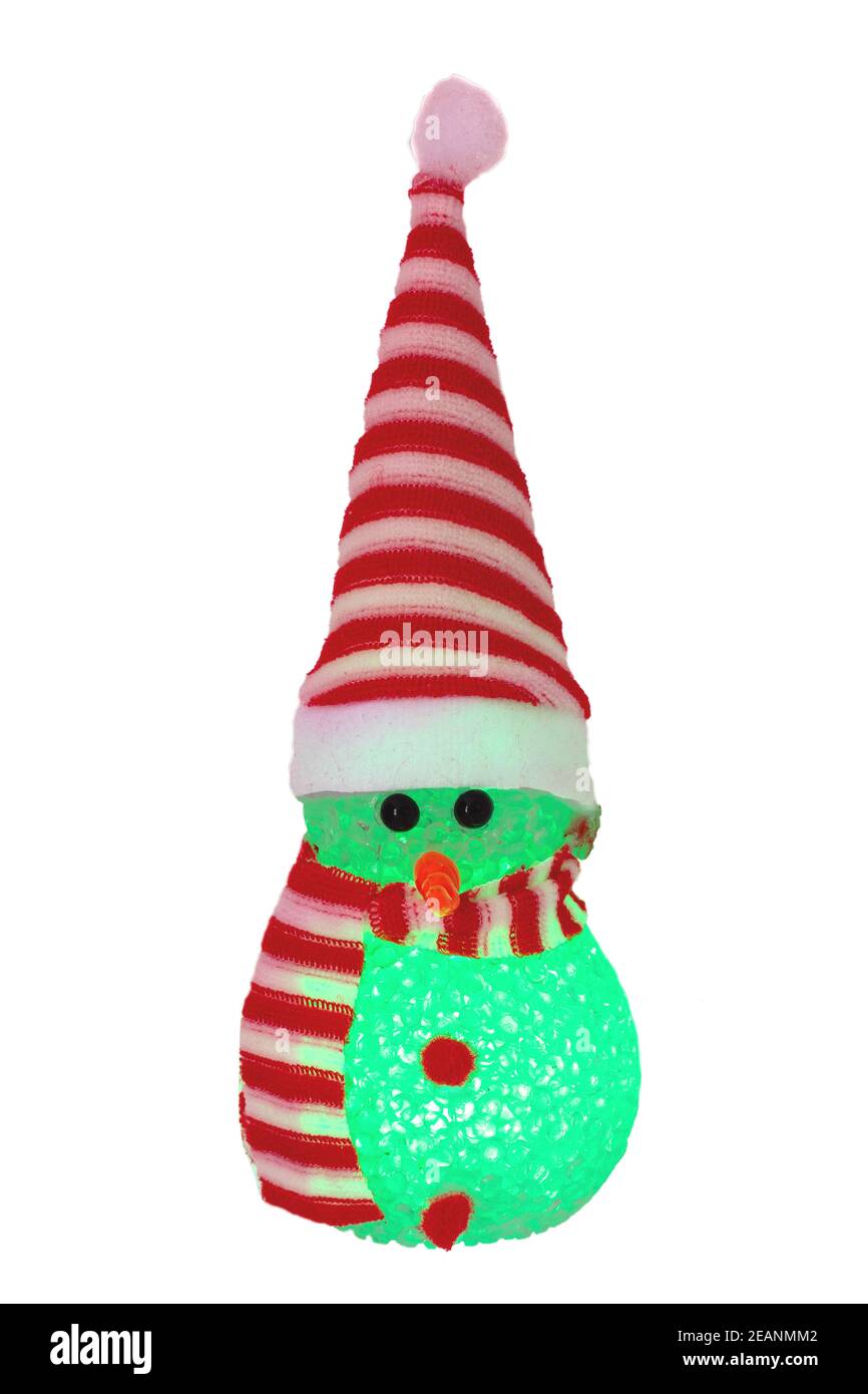 Christmas snowman isolated. Close-up of a green illuminated happy cute winter snowman with red white striped hat and scarf isolated on a white background. Macro photograph. Stock Photo