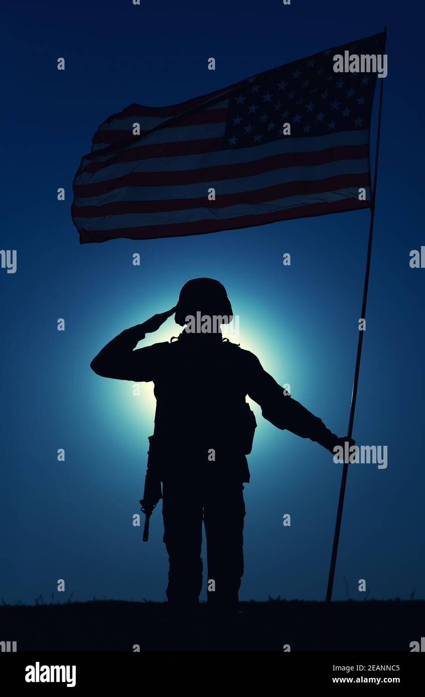 Silhouette of saluting US army soldier with flag Stock Photo