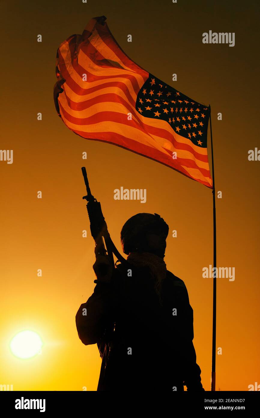 Silhouette of US soldier under national flag Stock Photo