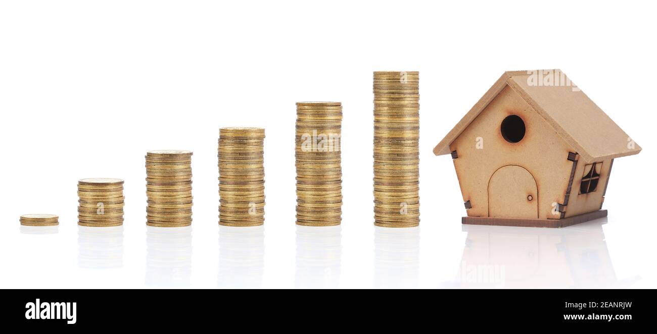 Savings. Investment concept with coins and a wodden house. Stock Photo