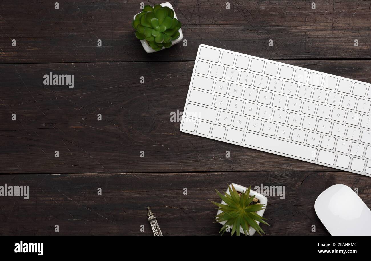 white wireless keyboard and mouse on a wooden brown table Stock Photo