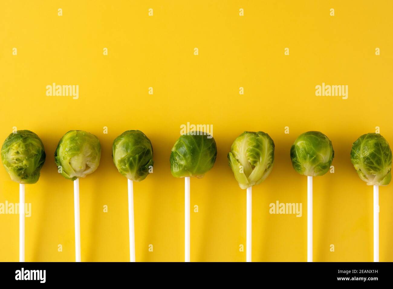 Set of brussel sprouts with lollipop sticks on yellow background Stock