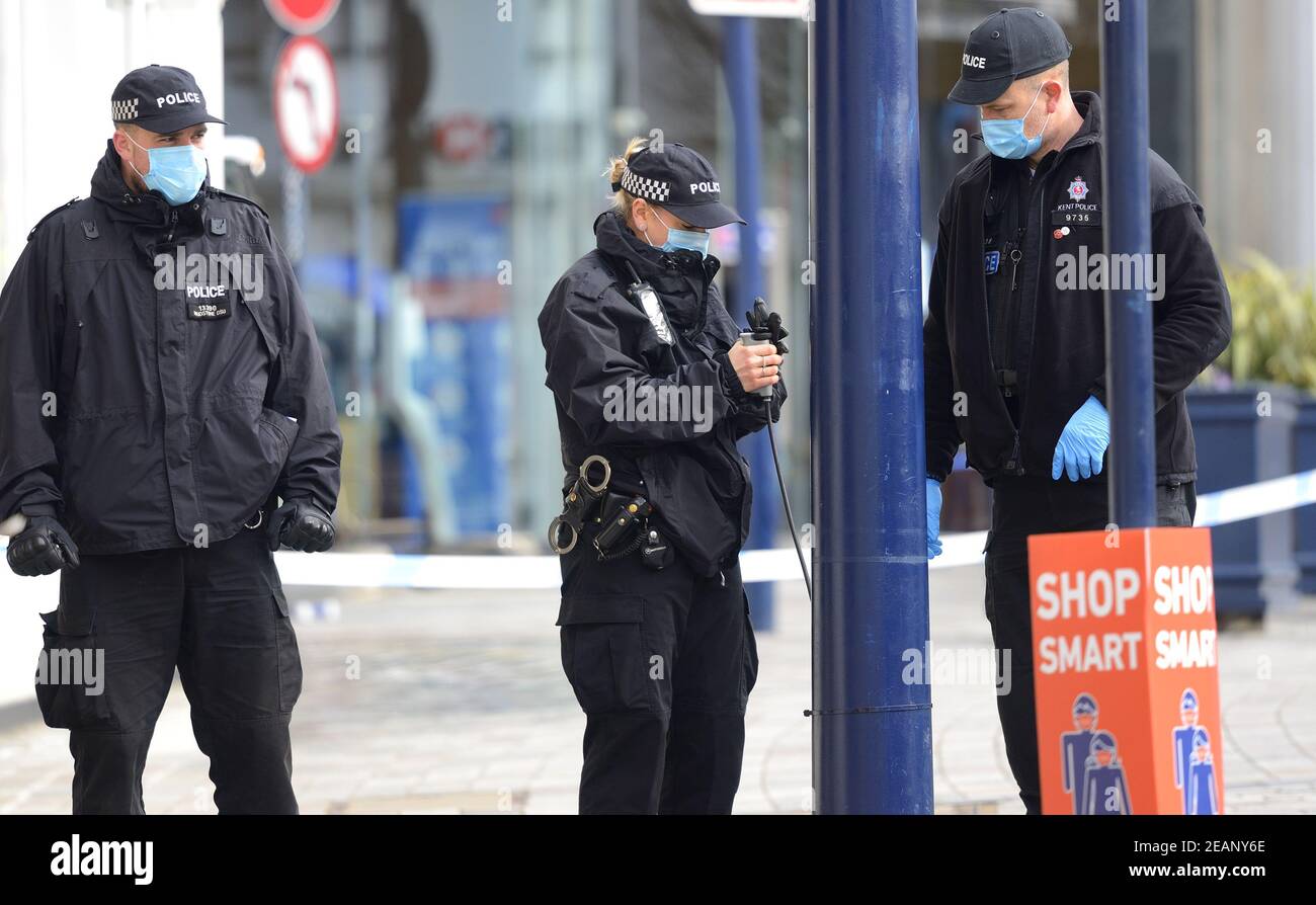 Maidstone, Kent, UK. Police officers conducting a search in the High Street after a stabbing. Female officer with fibre optic scope Stock Photo