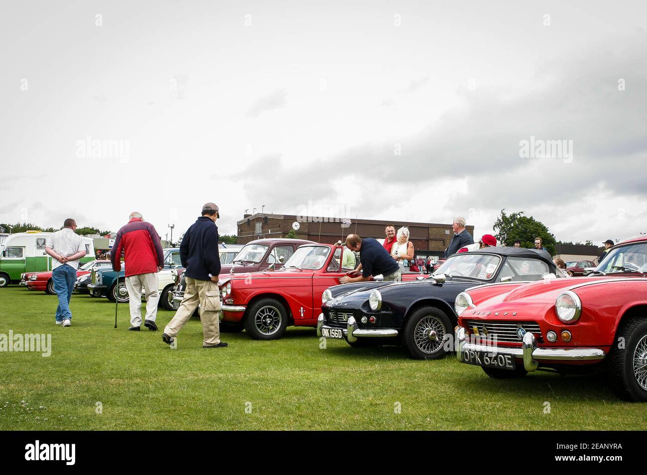 Car enthusiasts looking at selection of vintage and retro cars on