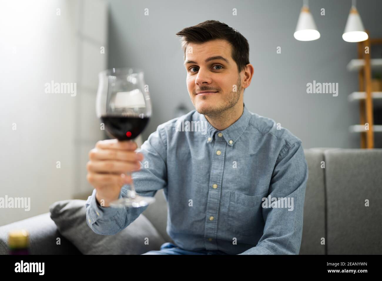 Man Drinking Red Wine In Video Conference Stock Photo