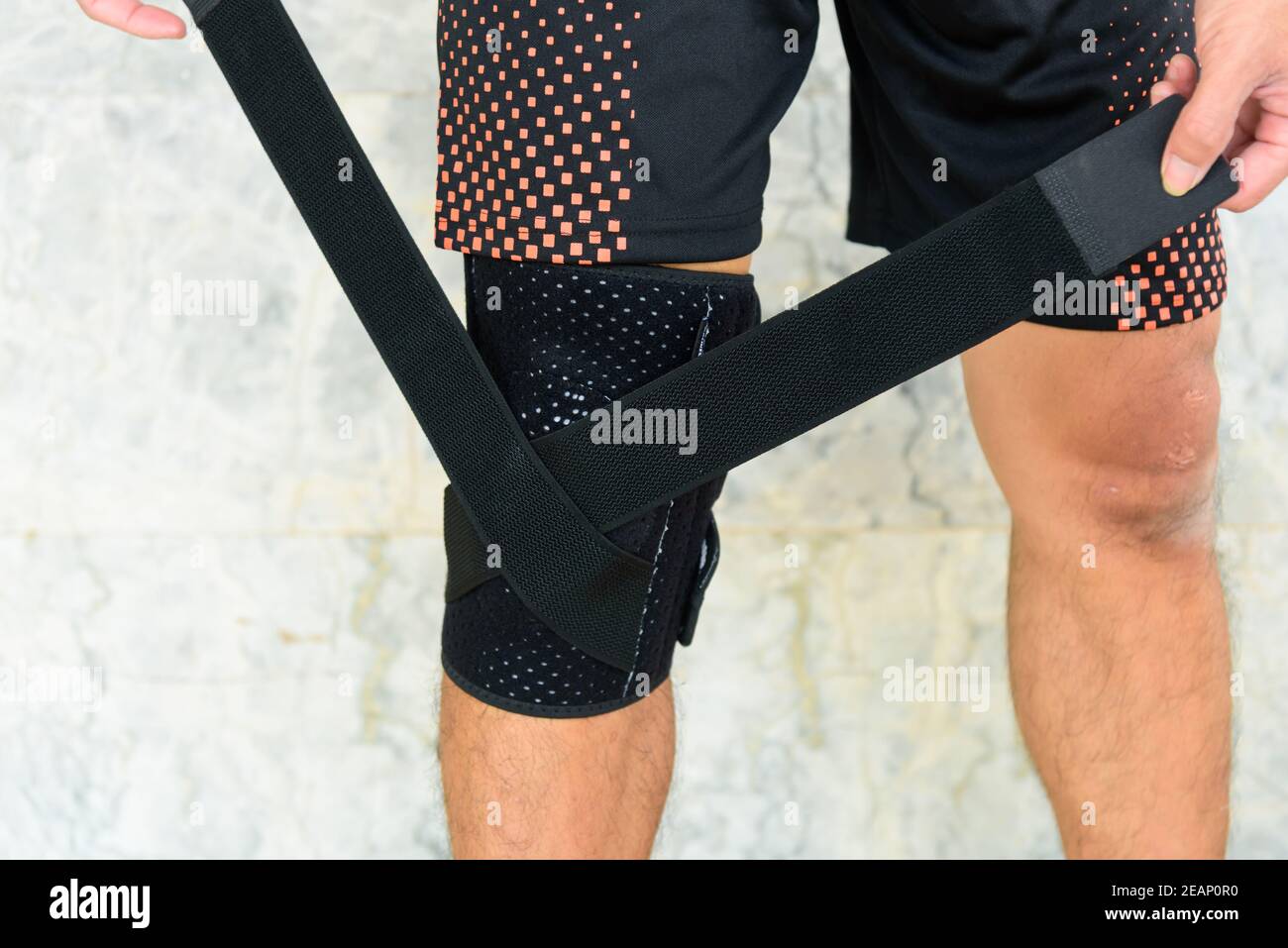 The man wear the Knee Support Brace Patella with sunlight in the park / Knee Pads Hole Sports Stock Photo