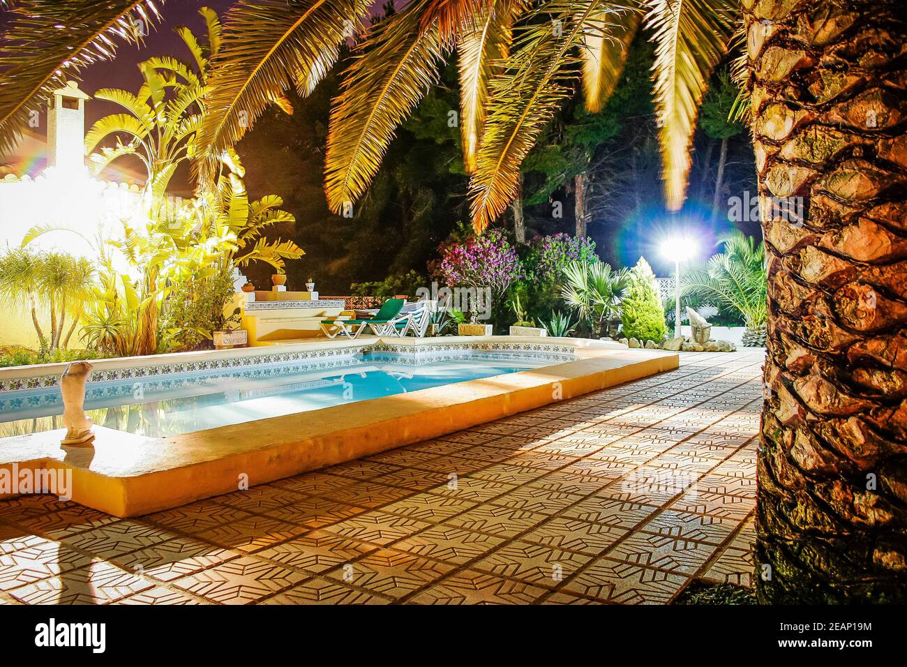 Swimming pool at night set in a mature garden at a classic Spanish villa in Moraira, Spain Stock Photo