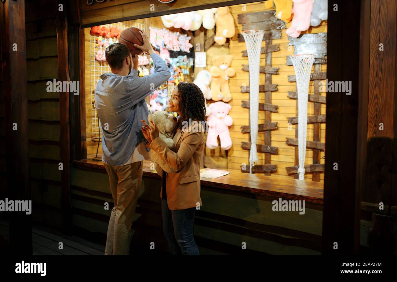 Couple play in shooting gallery, amusement park Stock Photo