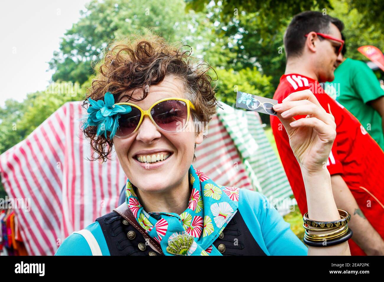 Smiley lady with fun blue flower sunglasses Underground Festival in Crystal Palace,South London Stock Photo