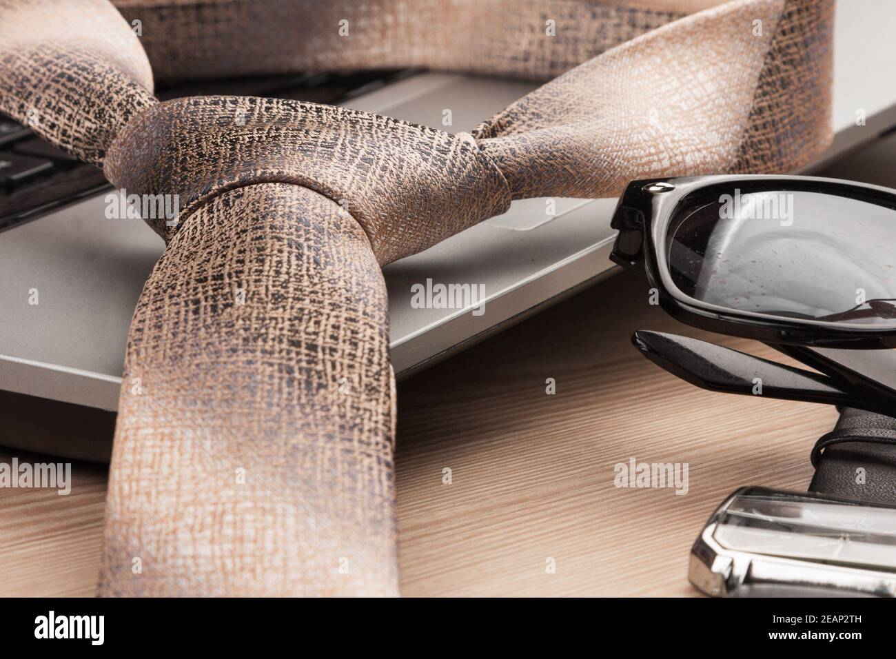 Fashion and business. Close-up, laptop and sunglasses, tie and watch, on a wooden table. Stock Photo
