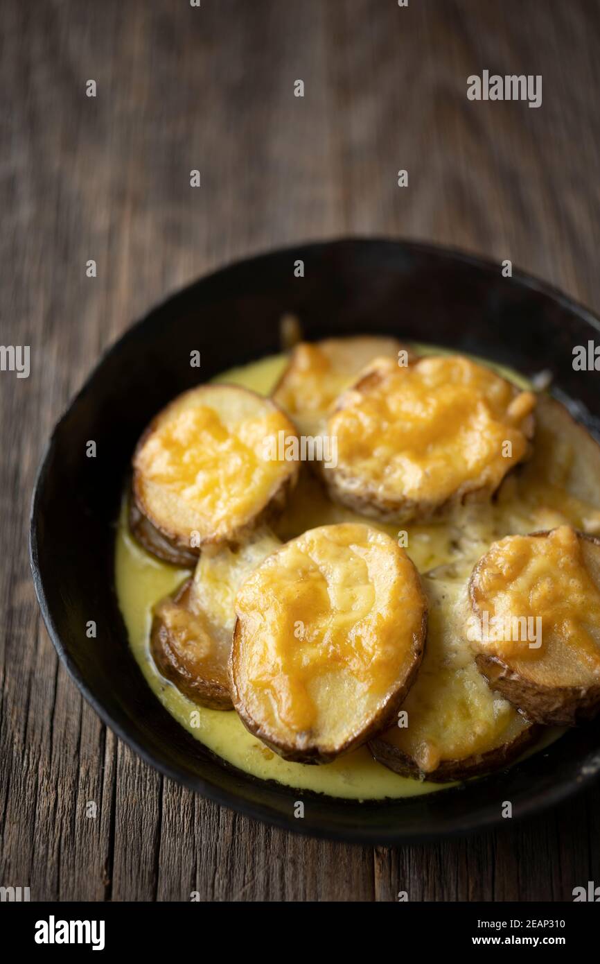 rustic spanish fried potatoes patatas bravas with cheese Stock Photo