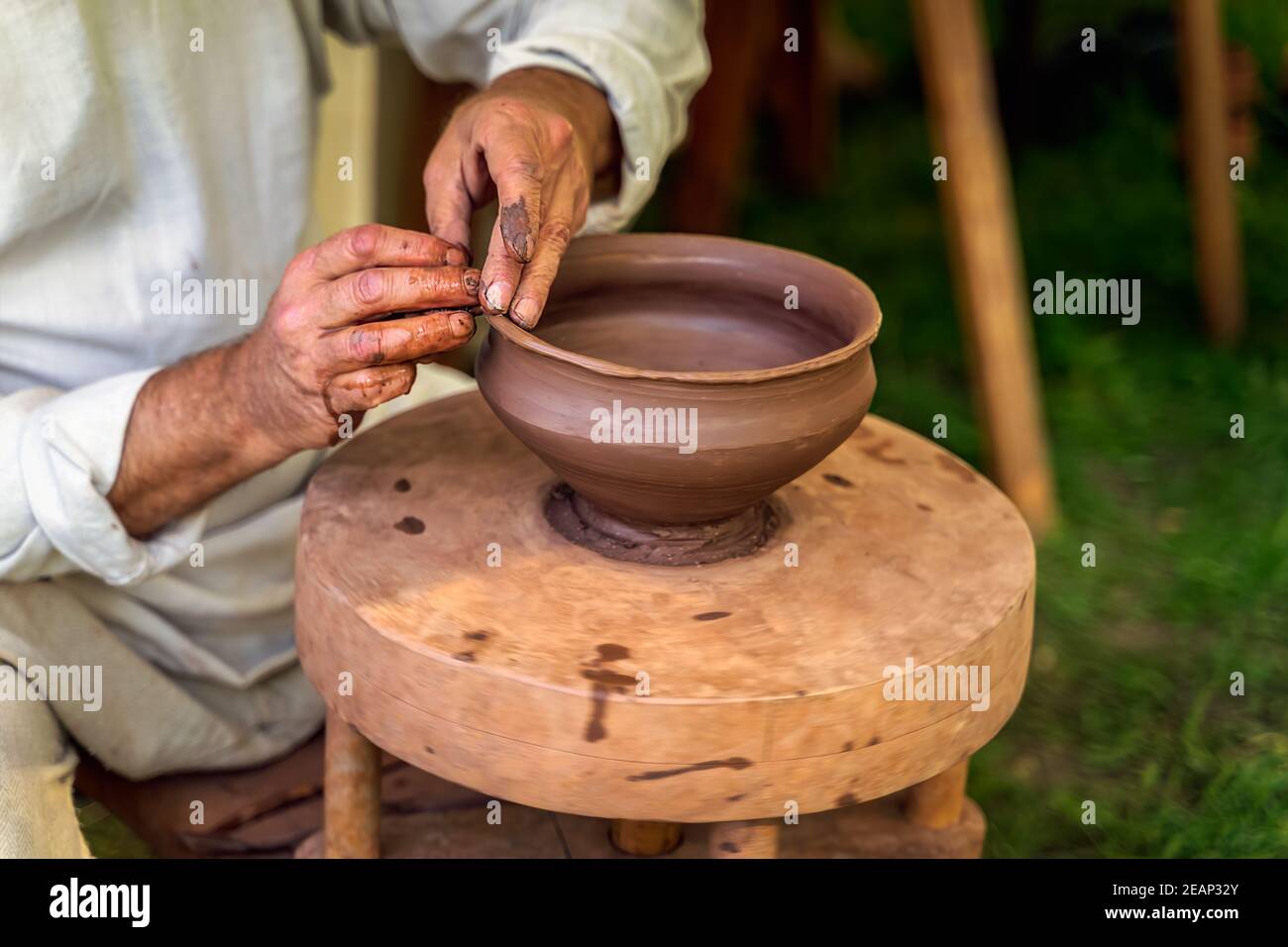 Craftsman hand making pottery from clay on potters wheel Stock Photo