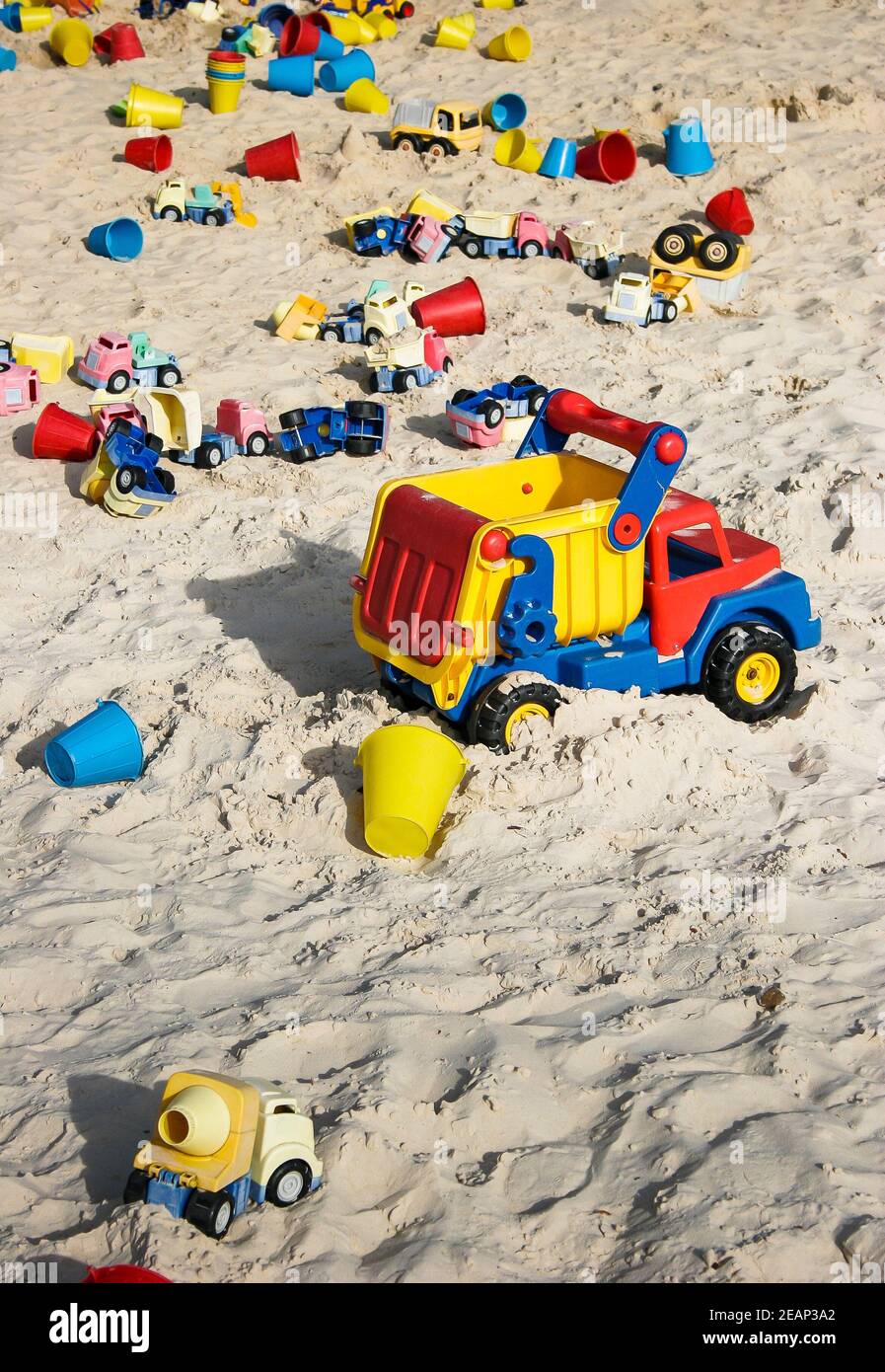 Huge sandpit with many toy dumper trucks for children's outdoor play in Godstone Farm, Surrey Stock Photo