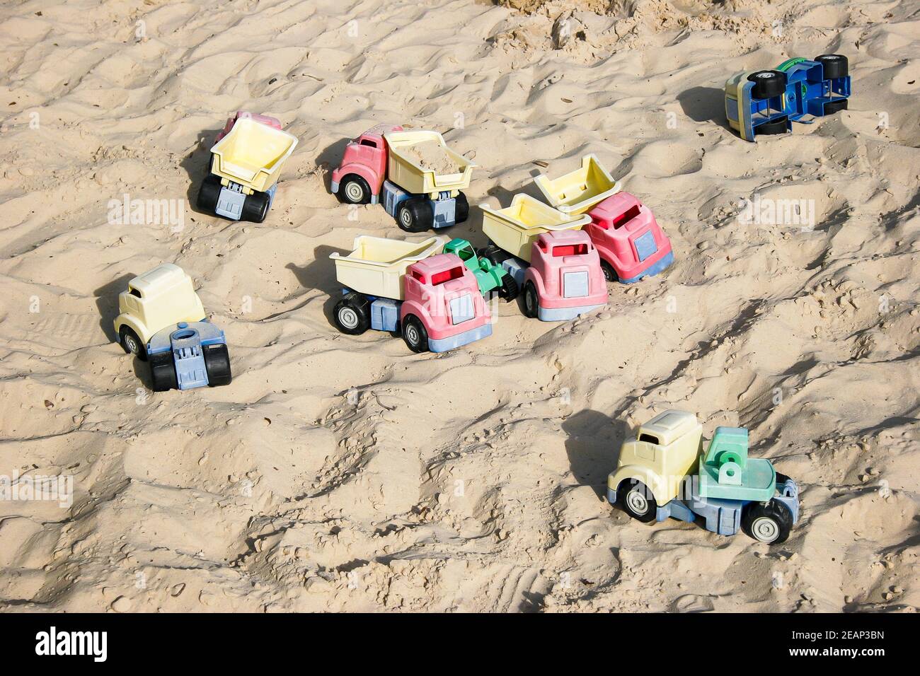 Huge sandpit with many toy dumper trucks for children's outdoor play in Godstone Farm, Surrey Stock Photo