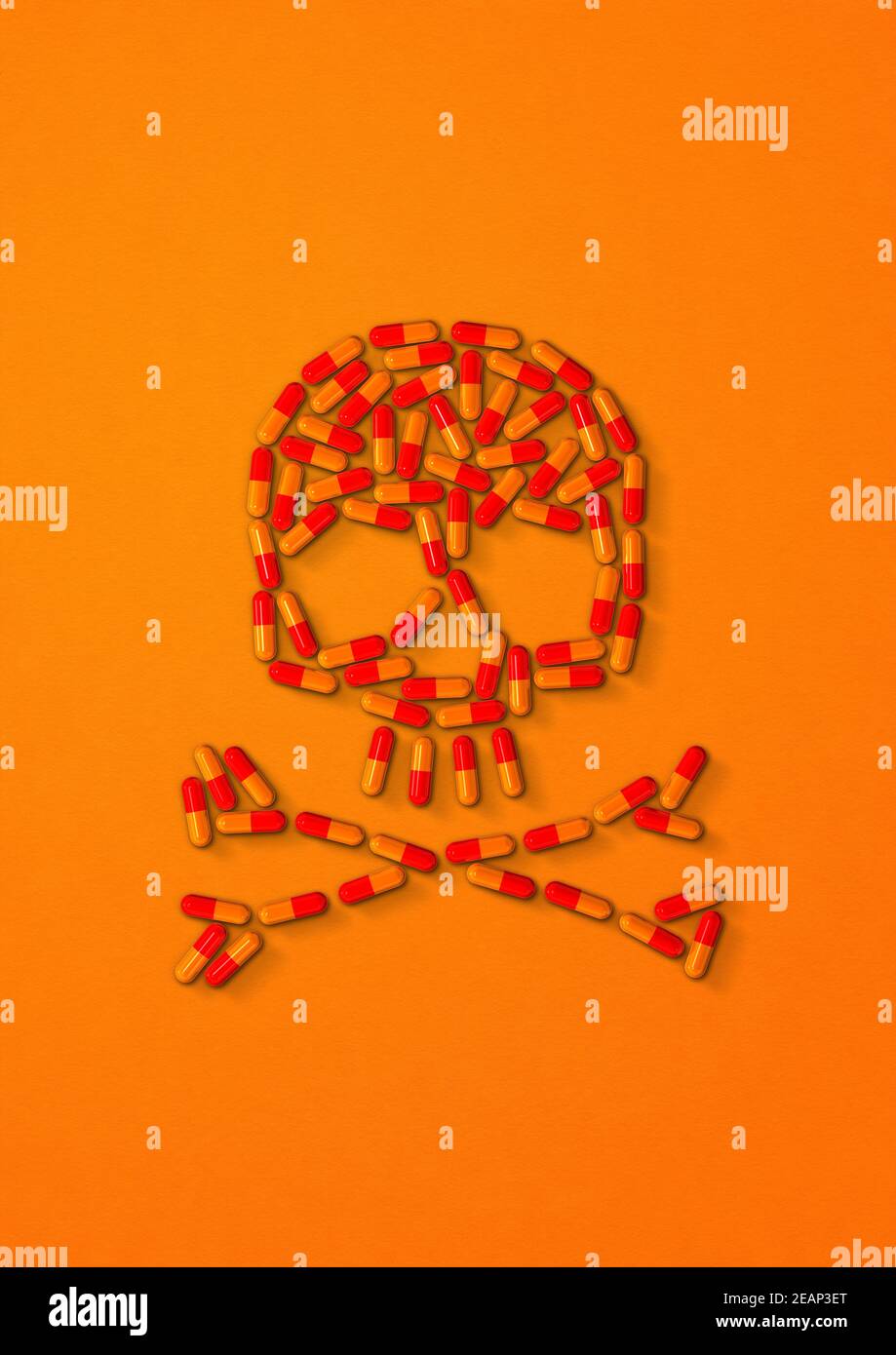 Skull made of capsule pills. Orange background Stock Photo