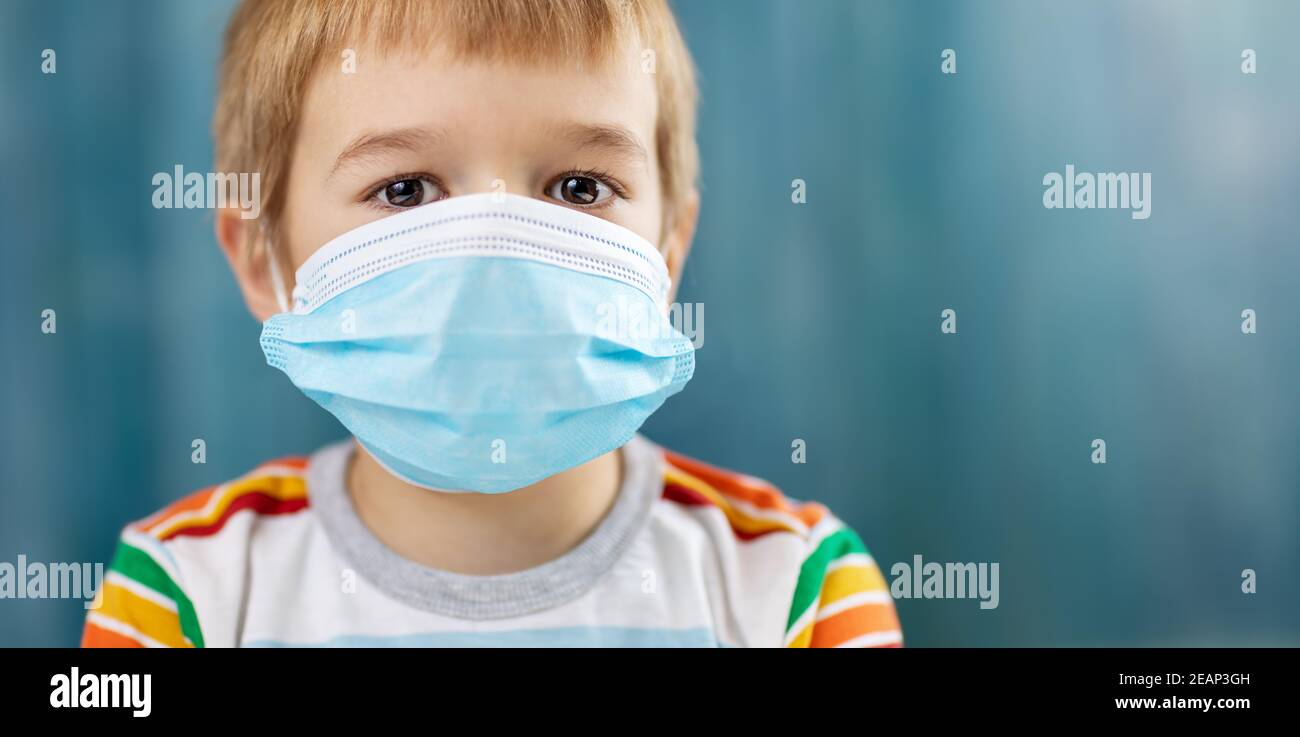 Boy in medical face protection mask indoors on blue background Stock ...