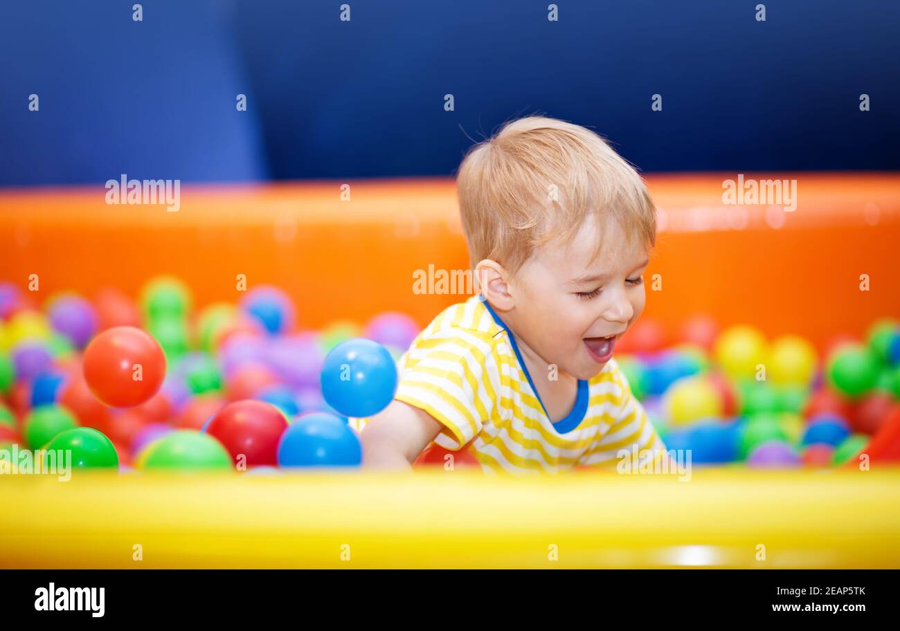 Little boy playing on playroom with ballpit Stock Photo