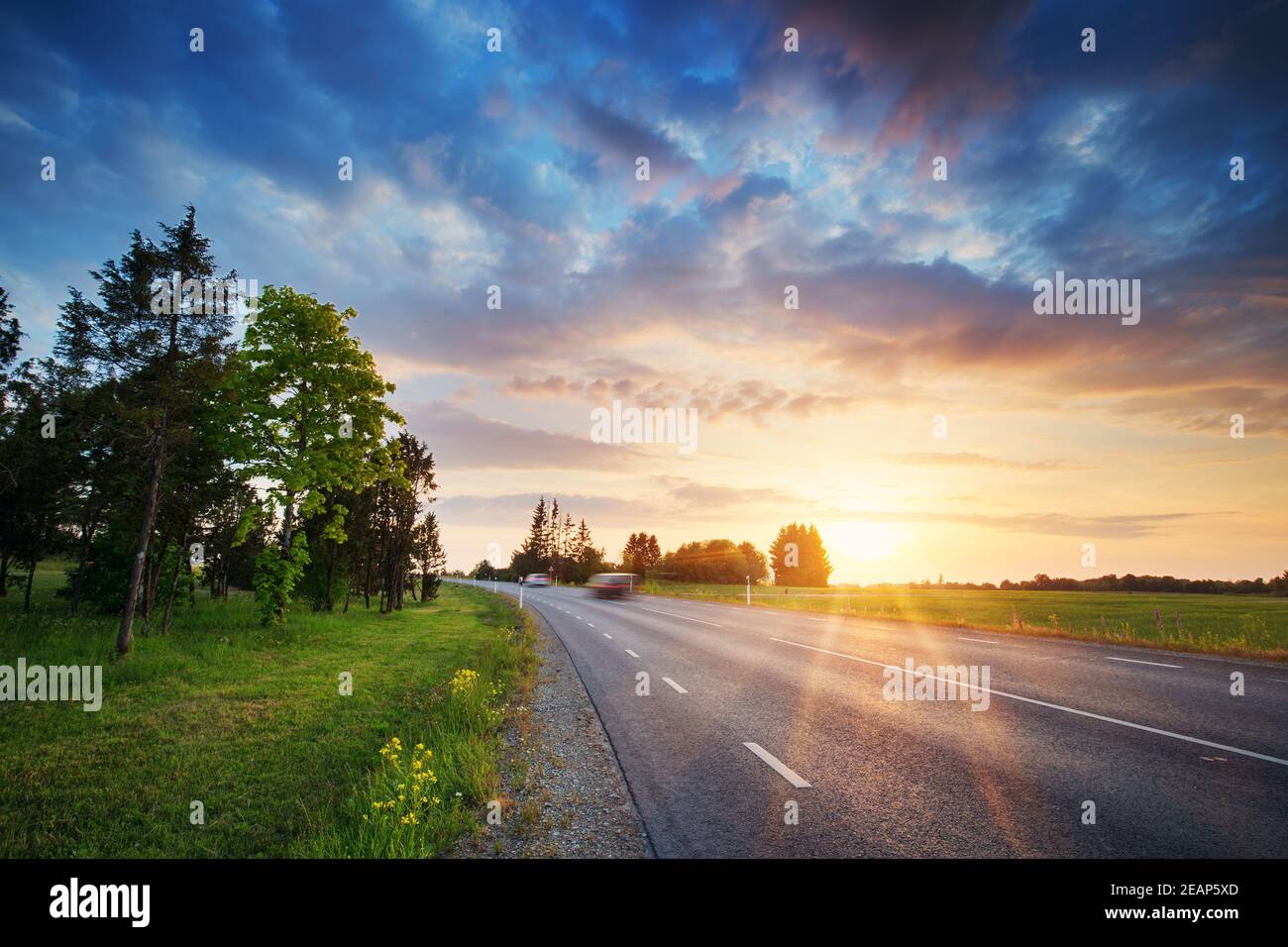 Asphalt road and dividing lines at sunset Stock Photo