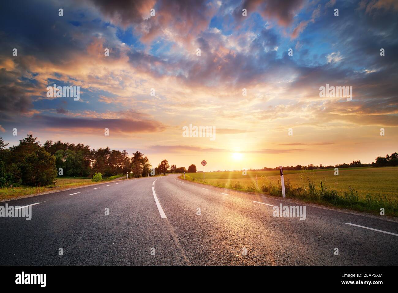 Asphalt road and dividing lines at sunset Stock Photo