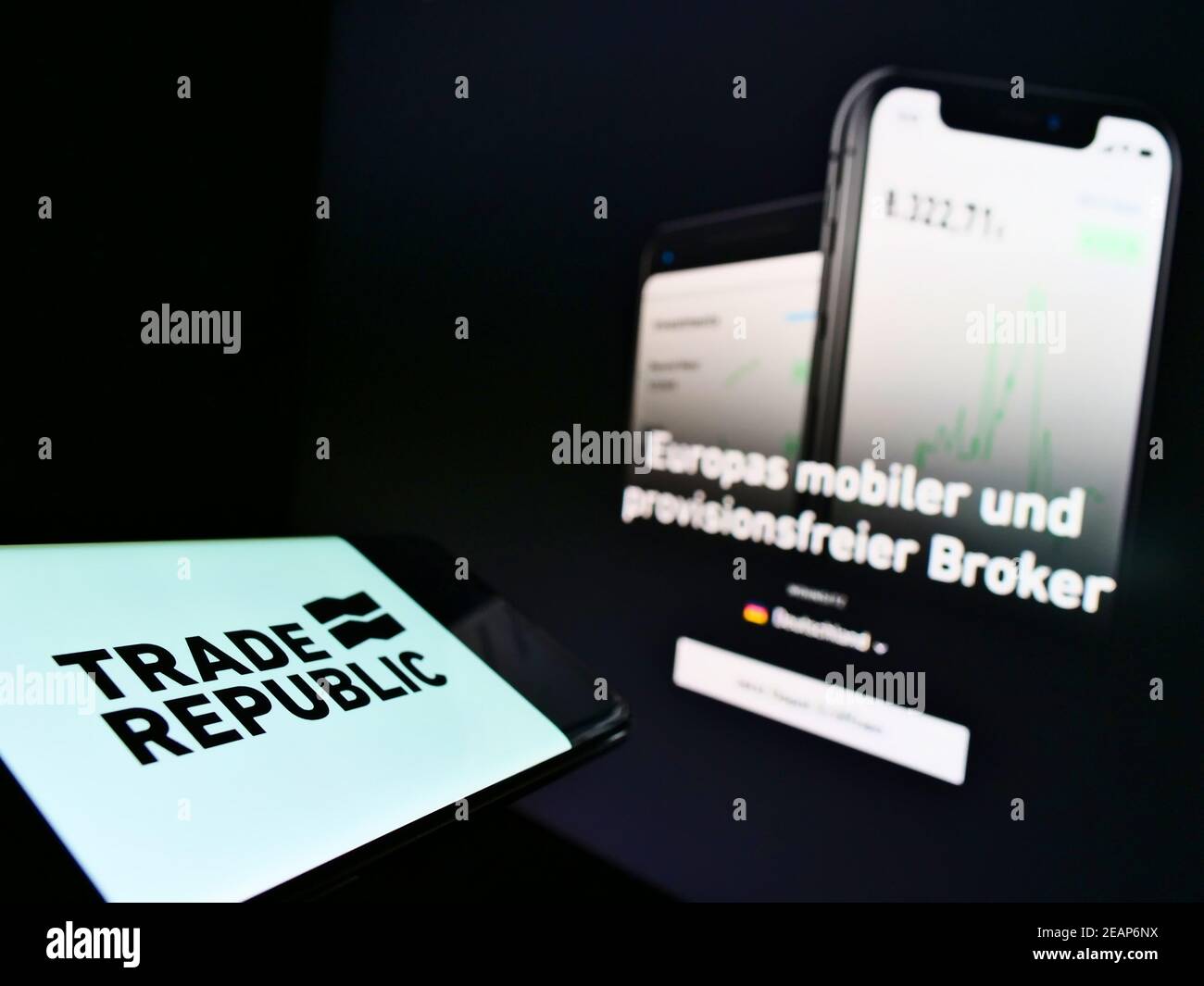 Smartphone with company logo of German online broker Trade Republic Bank GmbH on screen in front of webpage. Focus on phone center-left of display. Stock Photo