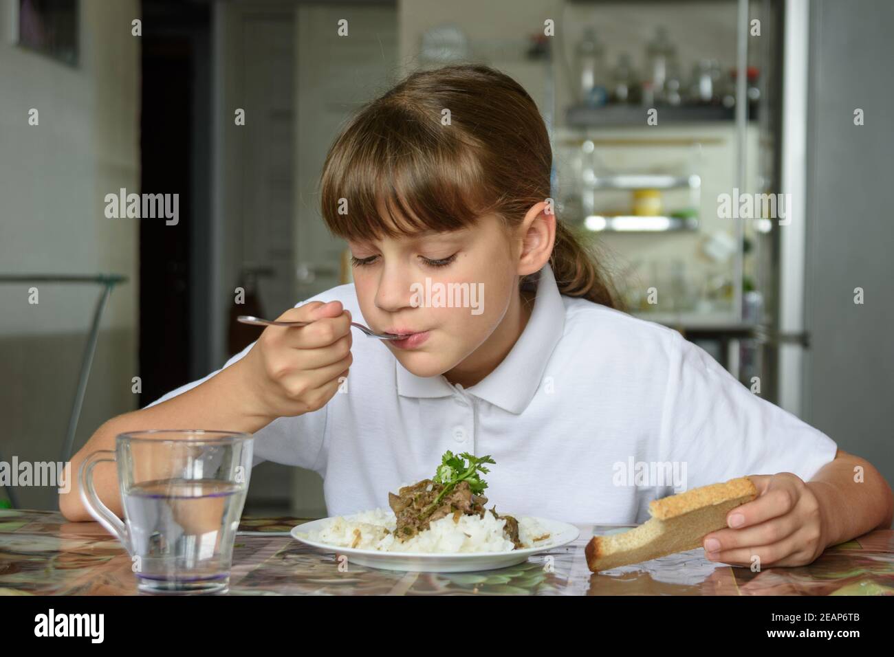 Girl eats the second dish for lunch Stock Photo