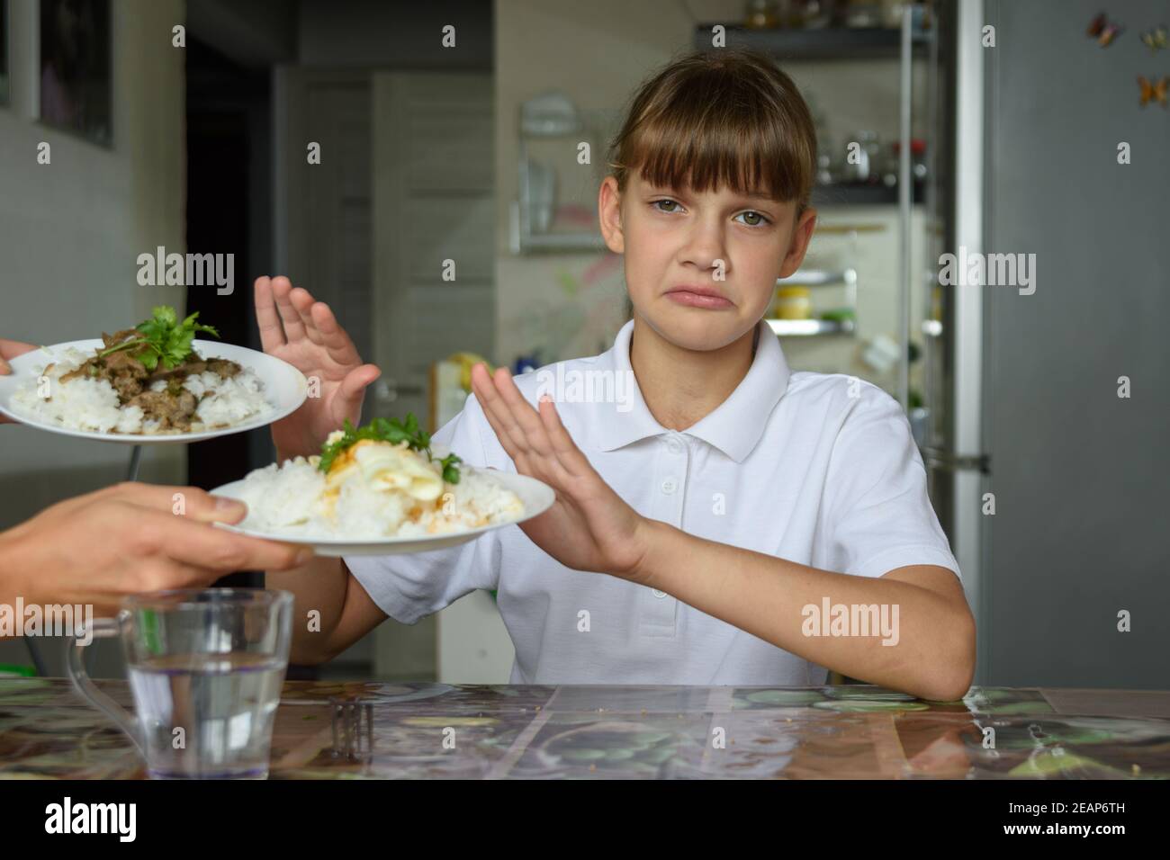 The girl refuses to eat and looks sadly into the frame Stock Photo