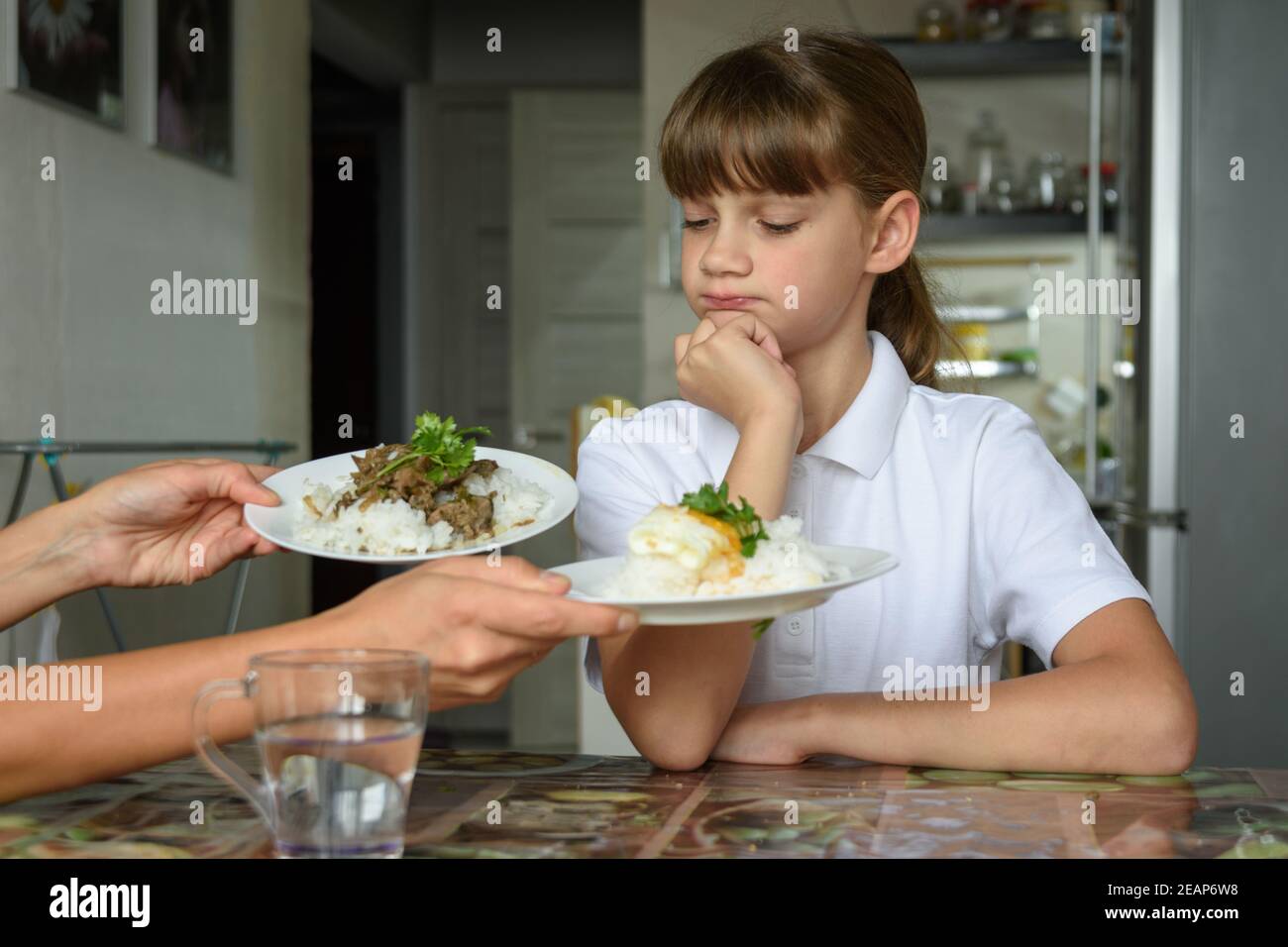The girl thoughtfully chooses a dish for lunch Stock Photo