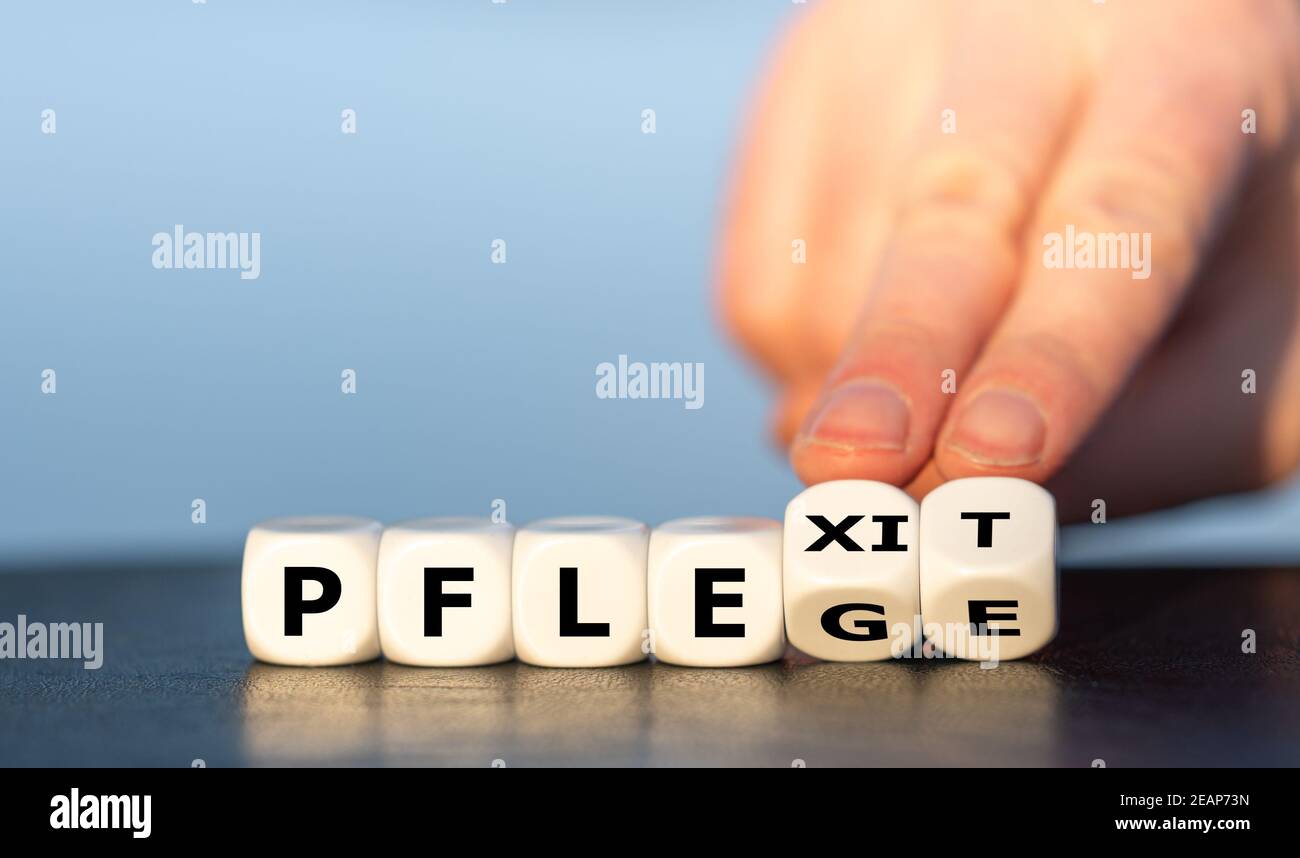 Symbol of health care workers quitting the job. Hand turns dice and changes the German expression 'Pflege' (care) to 'Pflexit' (word combination of ca Stock Photo