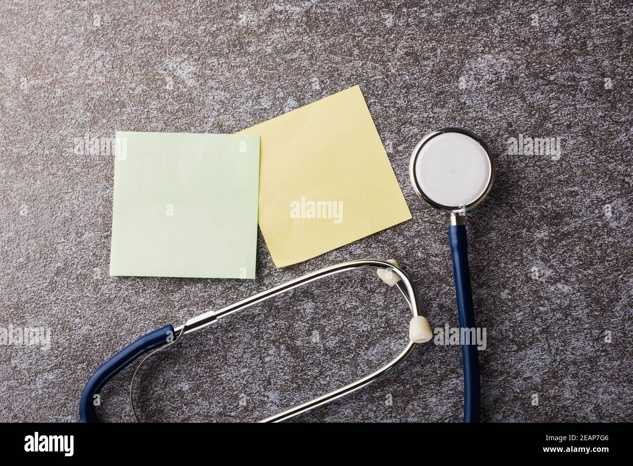 Doctor office table desk with blank paper stick note and stethoscope