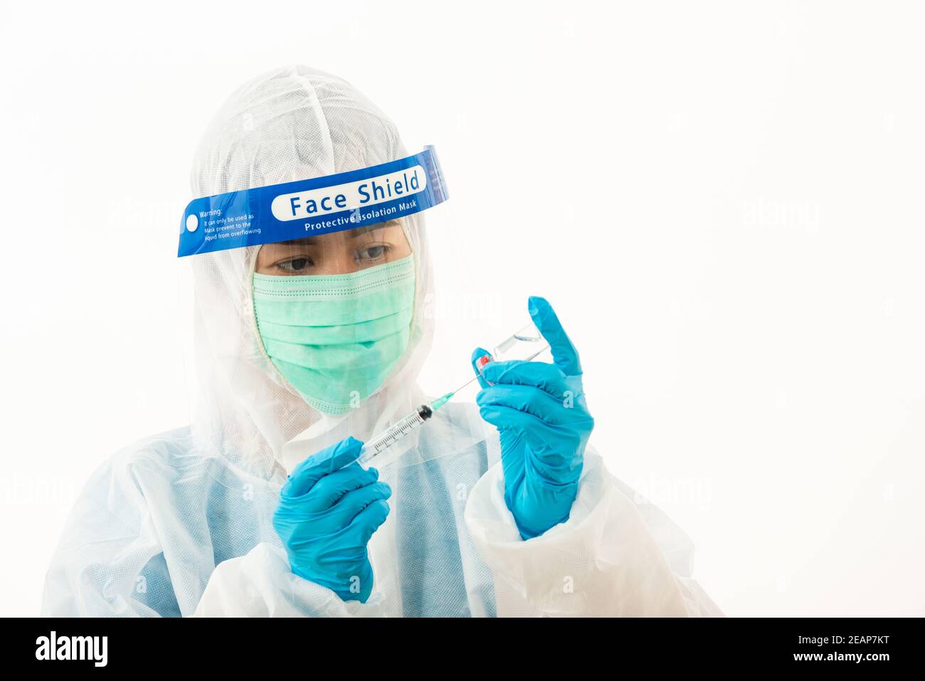 Woman medical scientist in PPE uniform wearing a face mask protective and plastic face shield holding for vaccine and syringe quarantine Coronavirus outbreak (COVID-19) isolated on white background Stock Photo