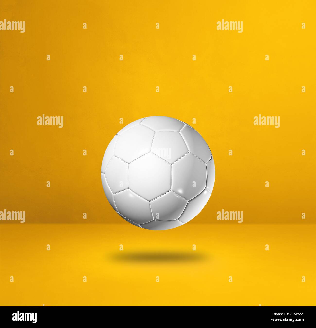 White soccer ball on a yellow studio background Stock Photo