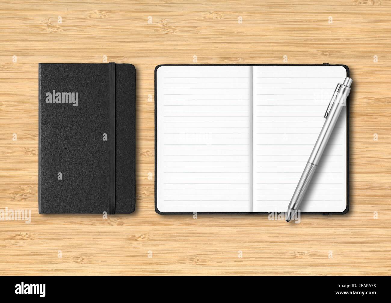 Black closed and open lined notebooks with a pen on wooden background Stock Photo