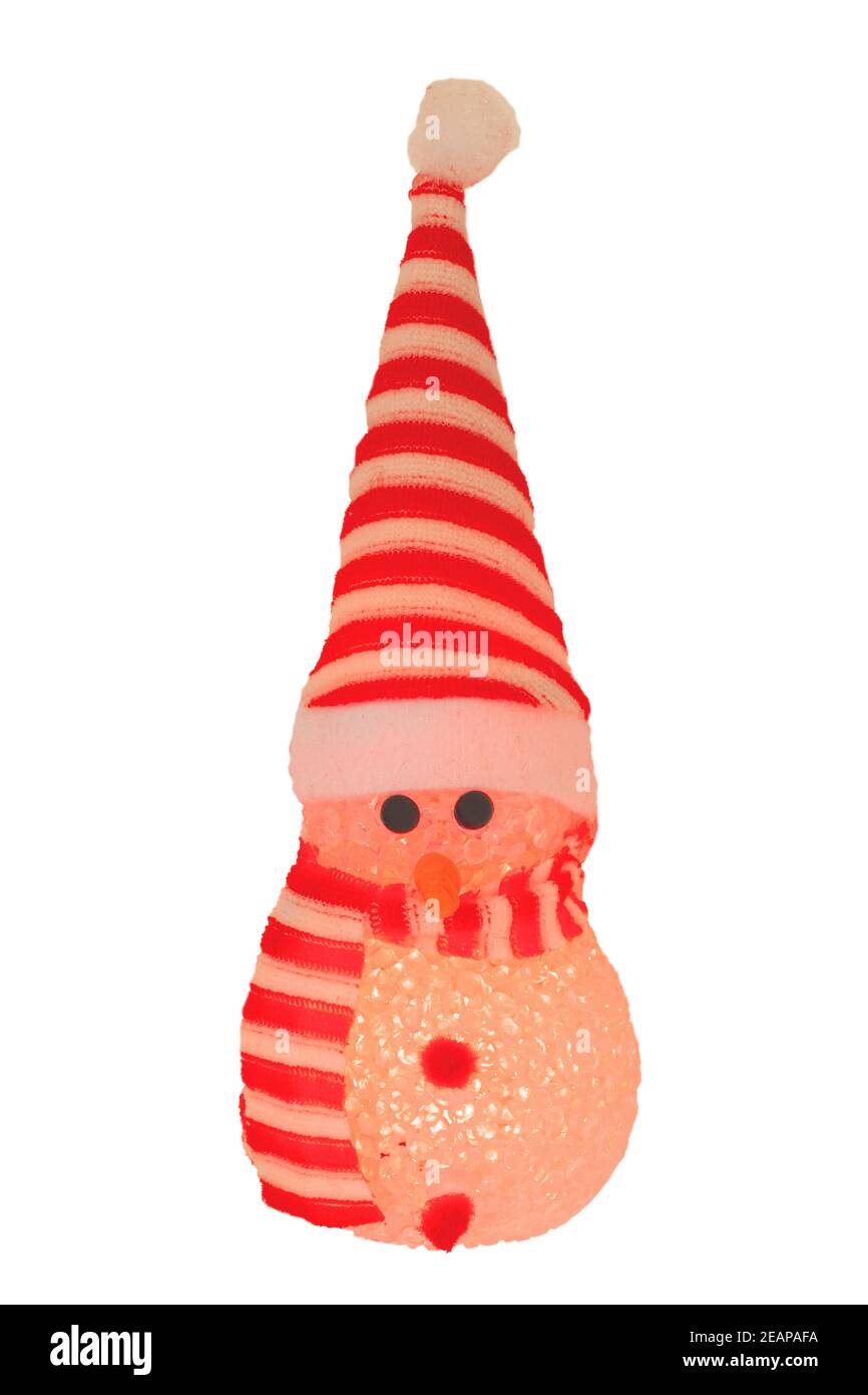 Christmas decoration isolated. Close-up of a yellow illuminated happy cute winter snowman with red white striped hat and scarf isolated on a white background. Macro photograph. Stock Photo