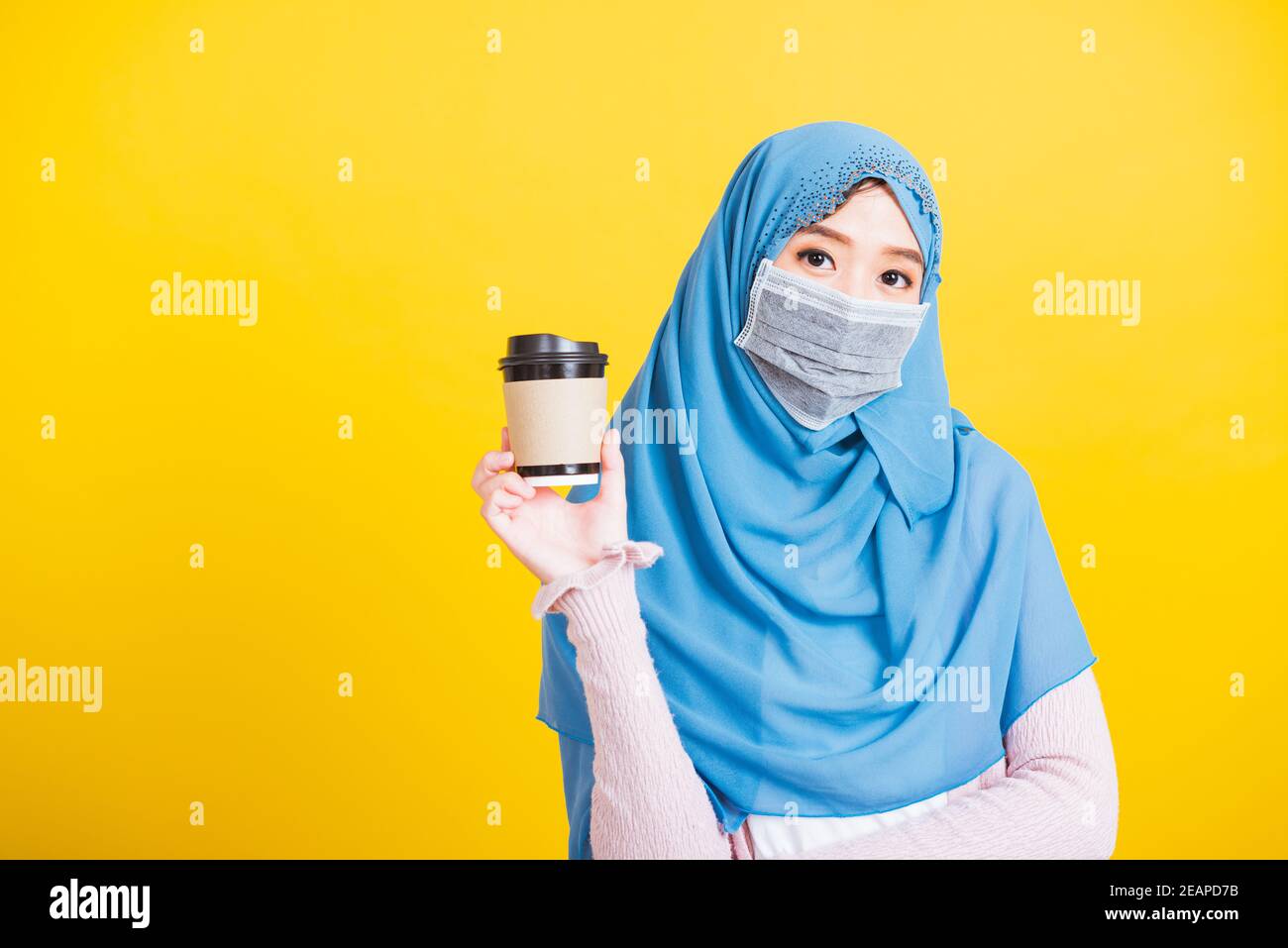 Asian Muslim Arab woman Islam wear veil hijab and face mask protect hold coffee paper cup Stock Photo