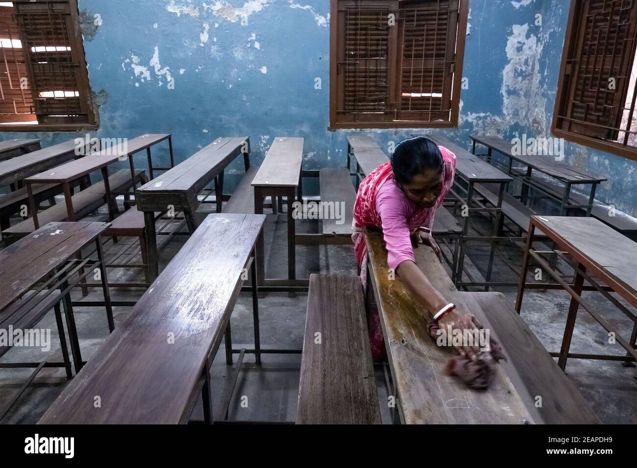 A staff member of Madhyamgram high school seen cleaning benches as the school prepares to reopen. The west Bengal government has decided to reopen schools across the state with proper covid 19 guidelines from 12th February. The schools will reopen for Classes 9 to 12 after ten months of being shut since March 16, 2020 due to the coronavirus pandemic. The state government has said that students will only be allowed to attend offline classes with parental consent. (Photo by Dipayan Bose / SOPA Images/Sipa USA) Stock Photo
