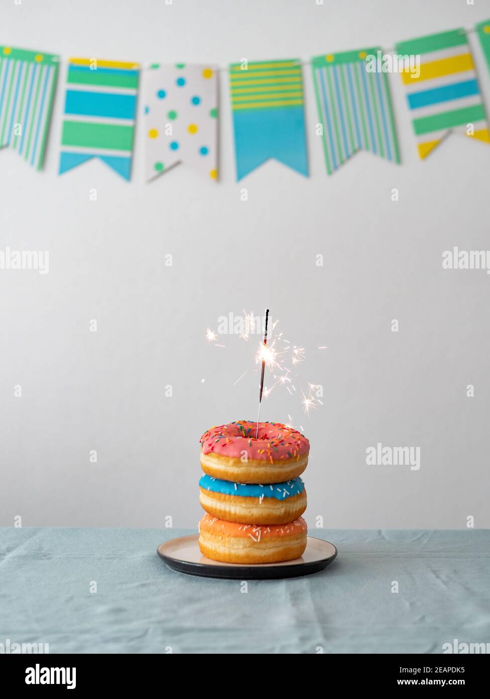 Birthday donuts cake with sparkler on table Stock Photo