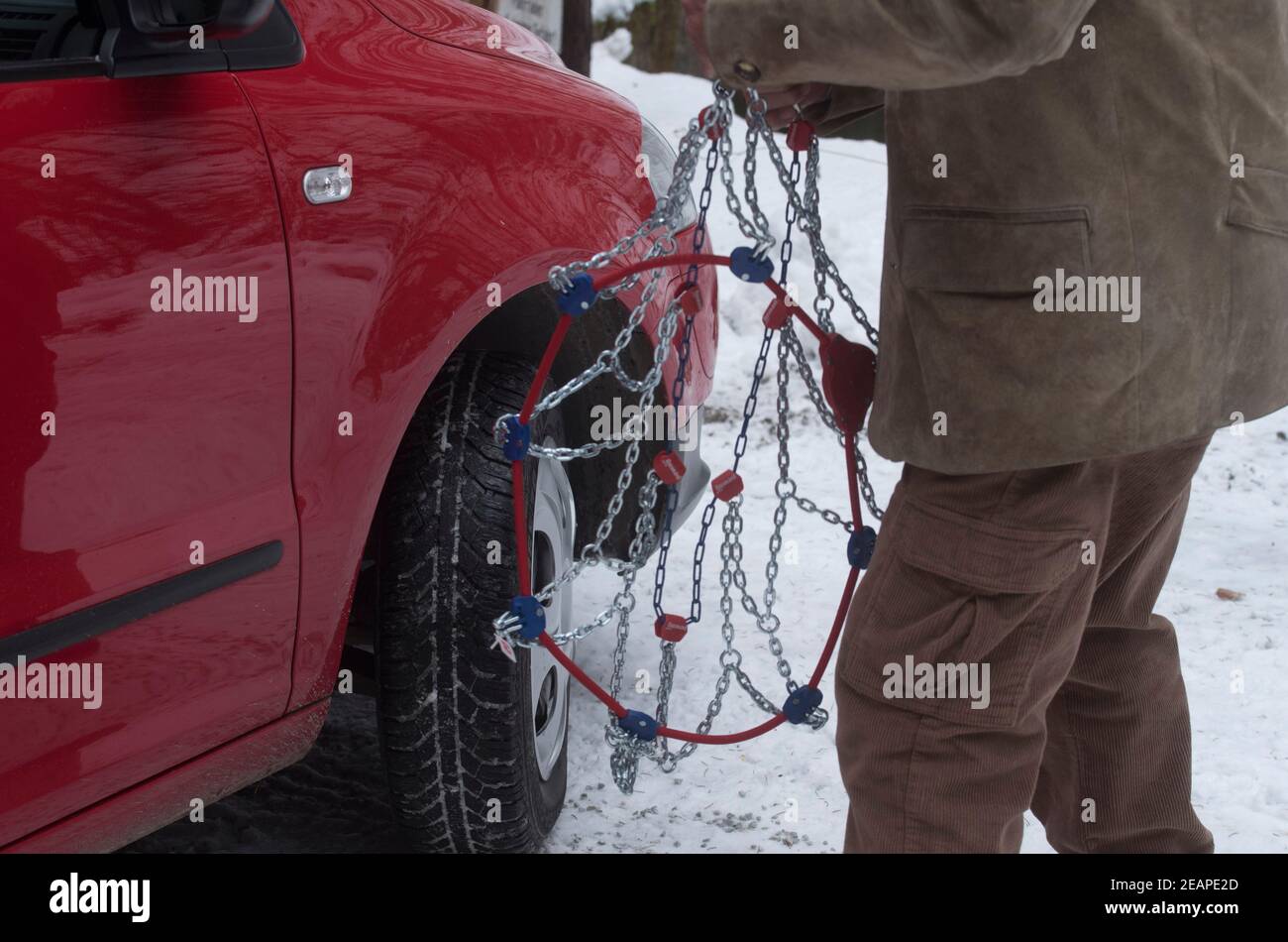 putting on snow chains on a car Stock Photo