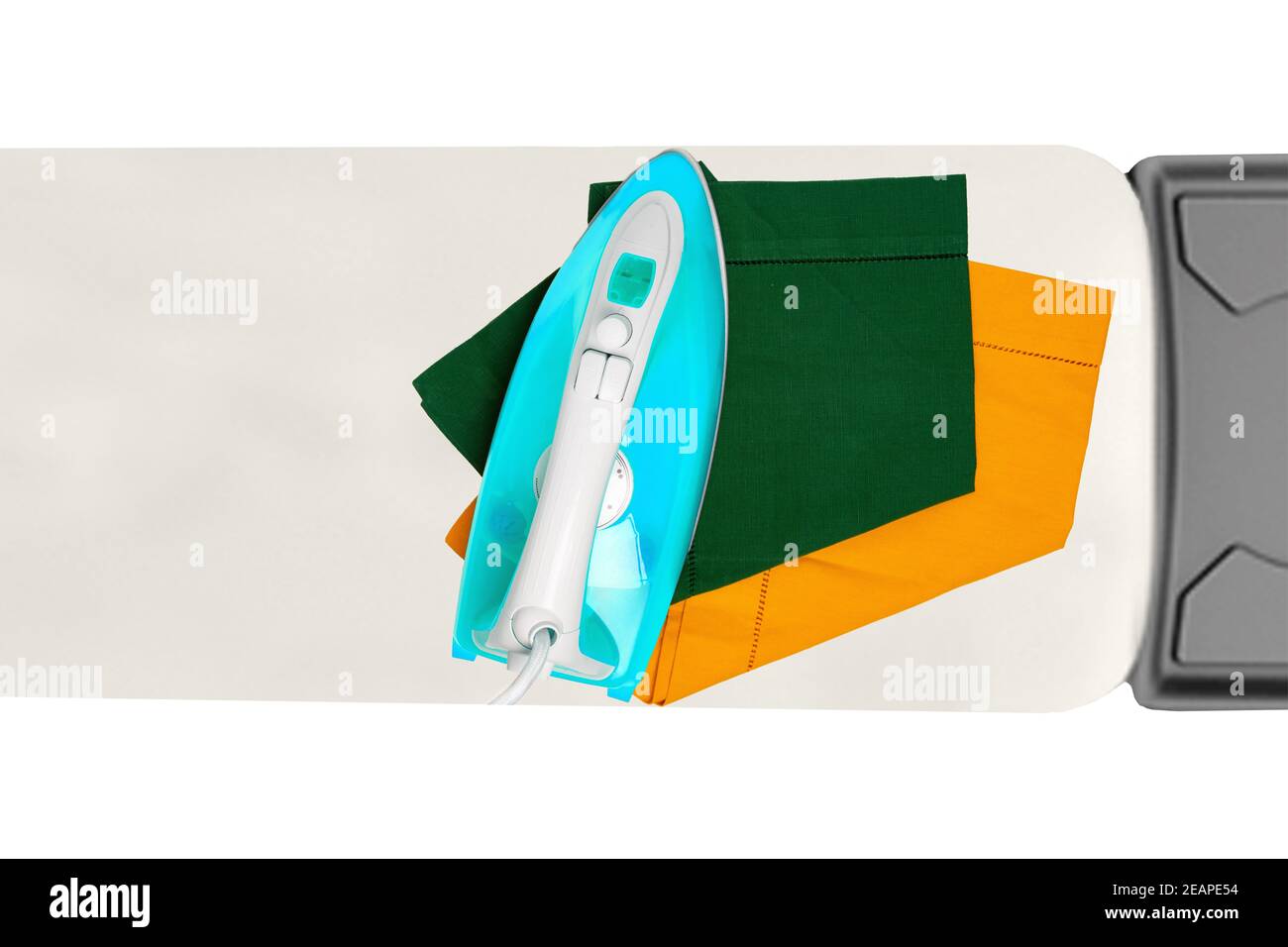 Top view of a modern electric blue iron ironing a green and a yellow cloth napkin on an ironing board indoors isolated. Advertising for the laundry service with space. Stock Photo