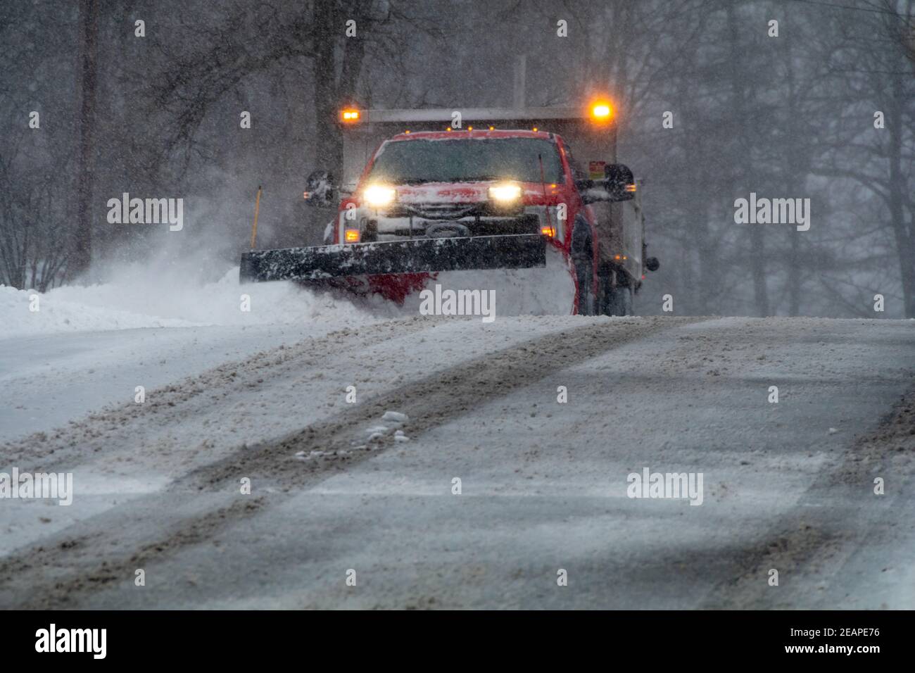 Snowplow in action clearing residential roads during snow storm Stock ...