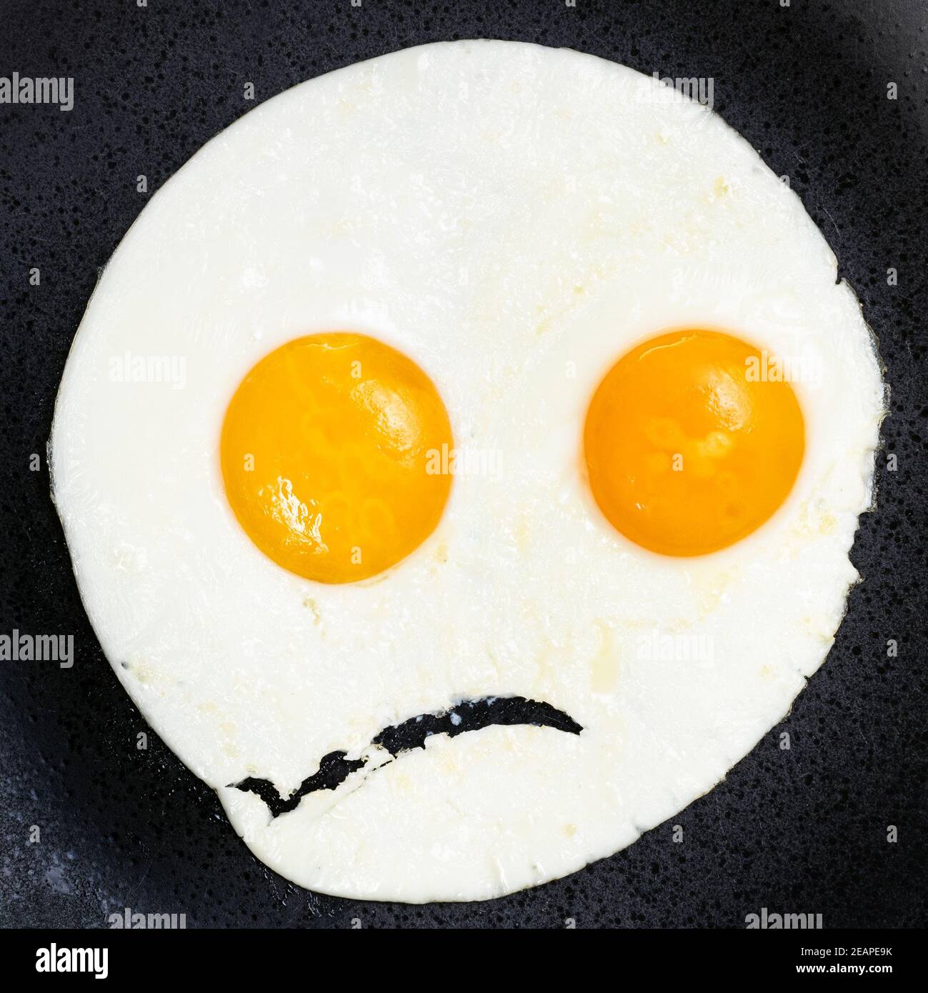 fried eggs on black plate close up Stock Photo