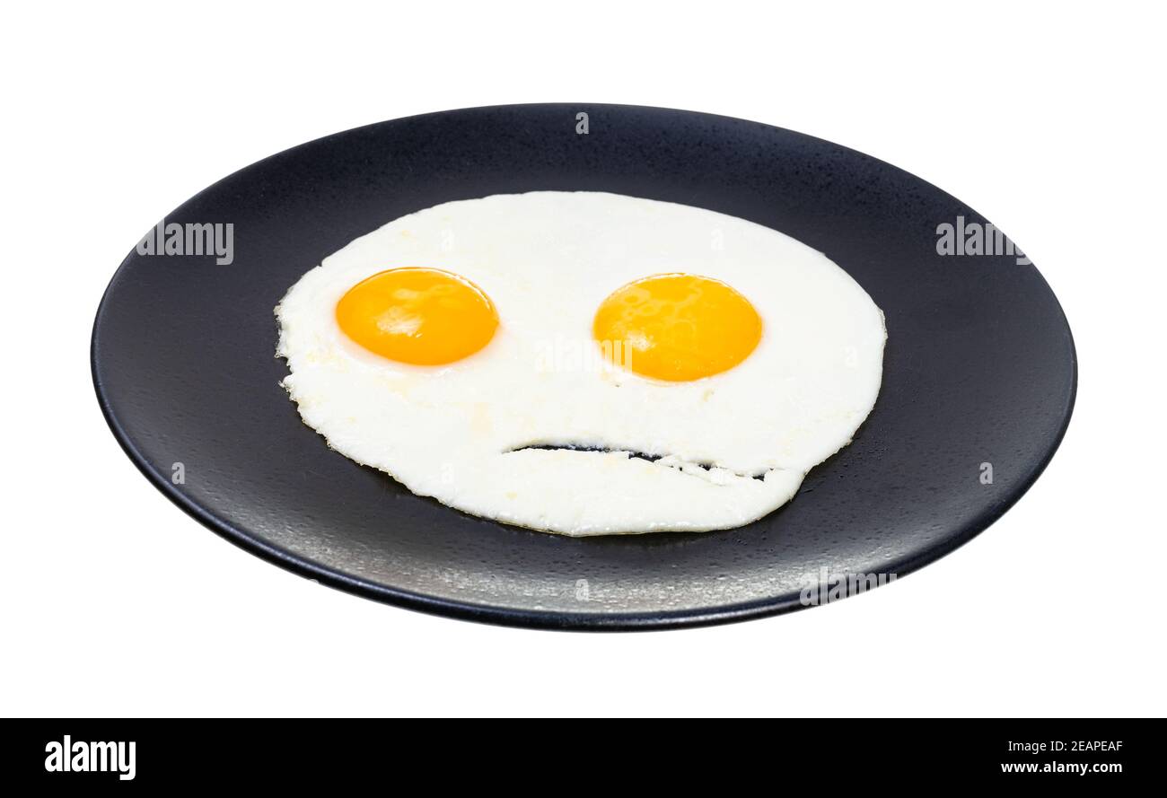 two fried eggs on black plate isolated on white Stock Photo