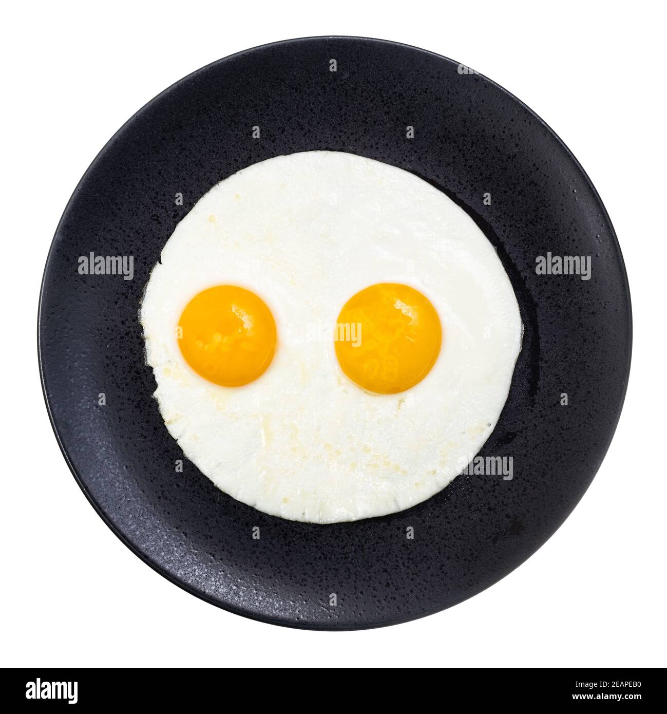 top view of fried eggs on black plate isolated Stock Photo - Alamy