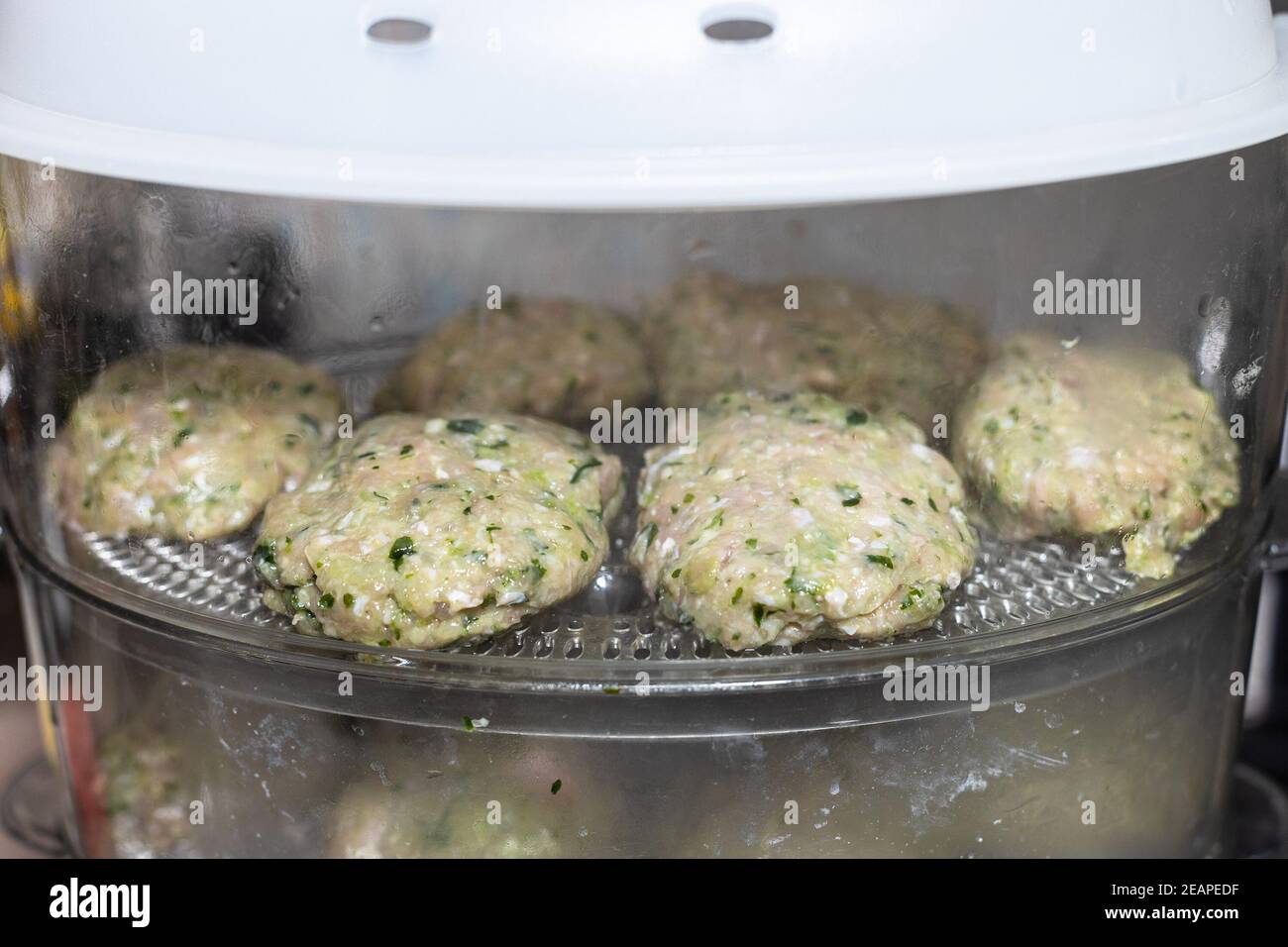 chicken cutlets with greens are cooked in steamer Stock Photo