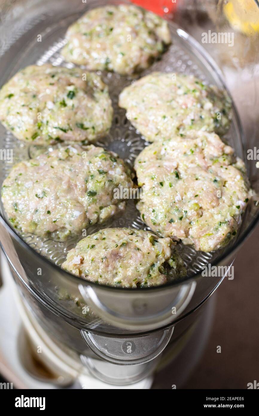 chicken cutlets are steaming in electric steamer Stock Photo