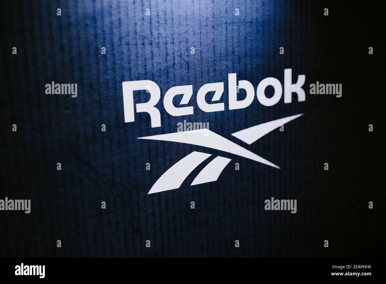 Reebok logo, on a blue background in neon light Stock Photo - Alamy
